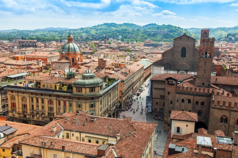 Vista panoramica di Bologna con i caratteristici tetti rossi e le cupole delle chiese storiche.