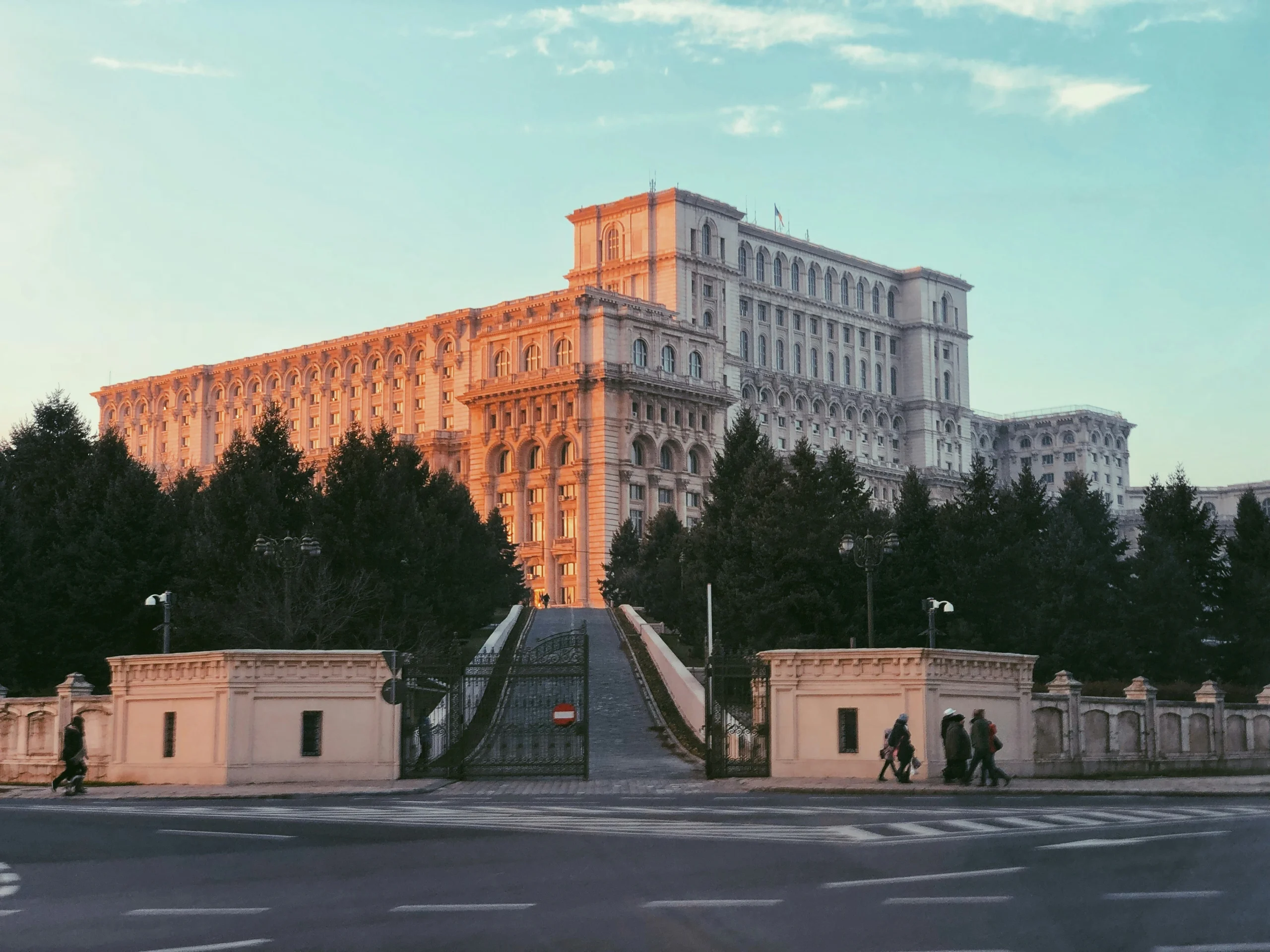 Veduta del Palazzo del Parlamento a Bucarest, uno degli edifici più grandi al mondo, sotto il cielo azzurro.
